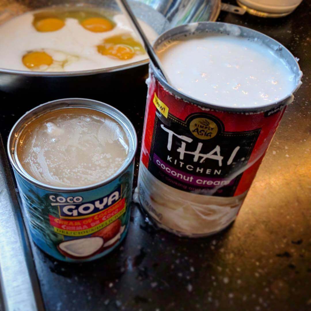 Open can of Goya coconut cream next to open can of Thai Kitchen coconut cream.