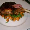 Pork chop with bbq sauce on sweet potato, bacon, greens.