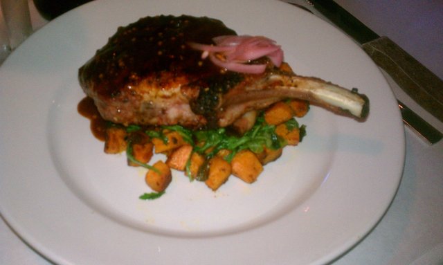 Pork chop with bbq sauce on sweet potato, bacon, greens.