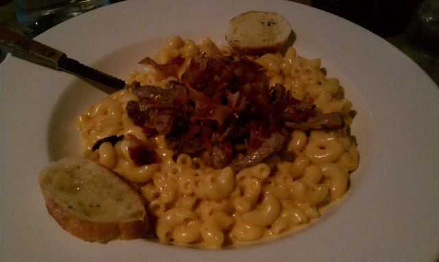 Mac-n-cheese with grilled steak and bacon strips.