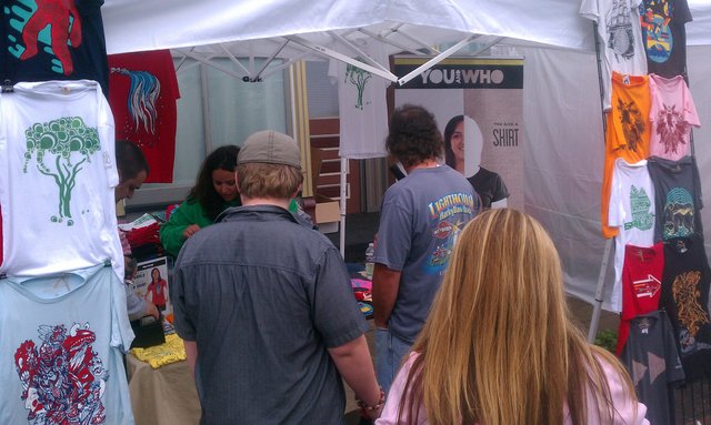 Come get your @You_and_Who shirts now, the stand is mobbed.