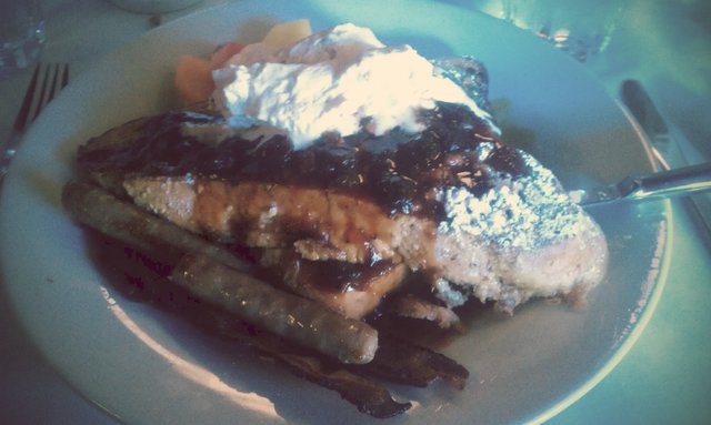 Giant French toast with Grand Marnier whipped cream, pecans, berries. Bacon & sausage.