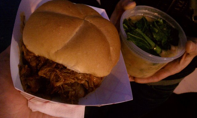 Trying the @WholeHogTruck BBQ pork sandwich, beans & greens. Awesome.