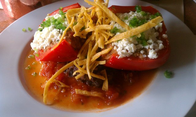 Chili relleno con puerco: roasted red pepper stuffed with carnitas, yellow rice, chipotle, ancho chili, queso fresco.