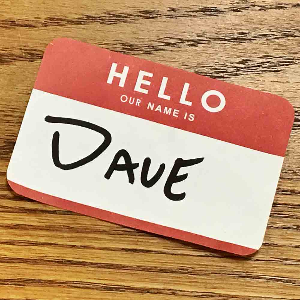 A name badge sticker that reads “Hello, our name is Dave.”