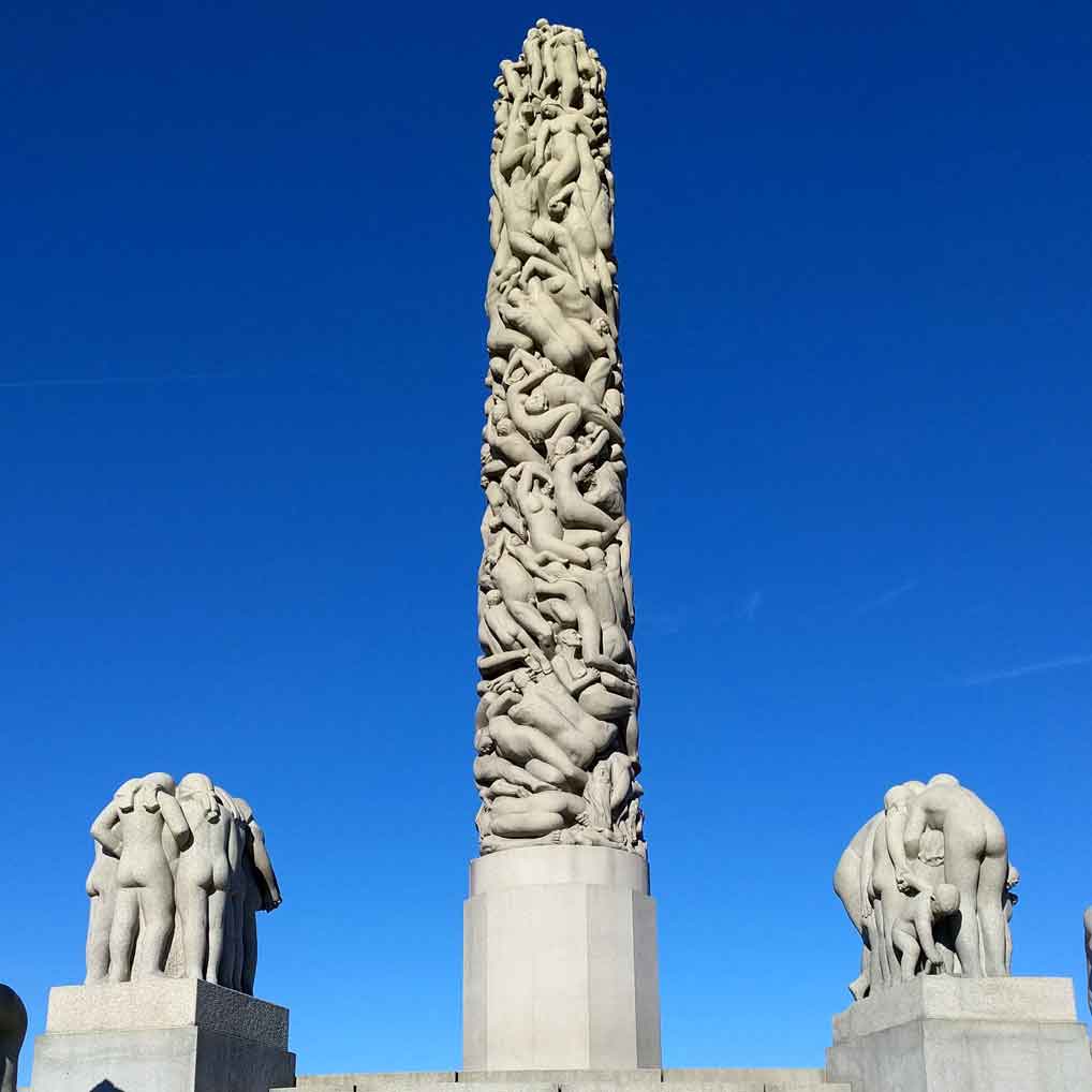 A thin stone column carved to appear as a 17 meter tall mass of 121 people, all of whom have heads.
