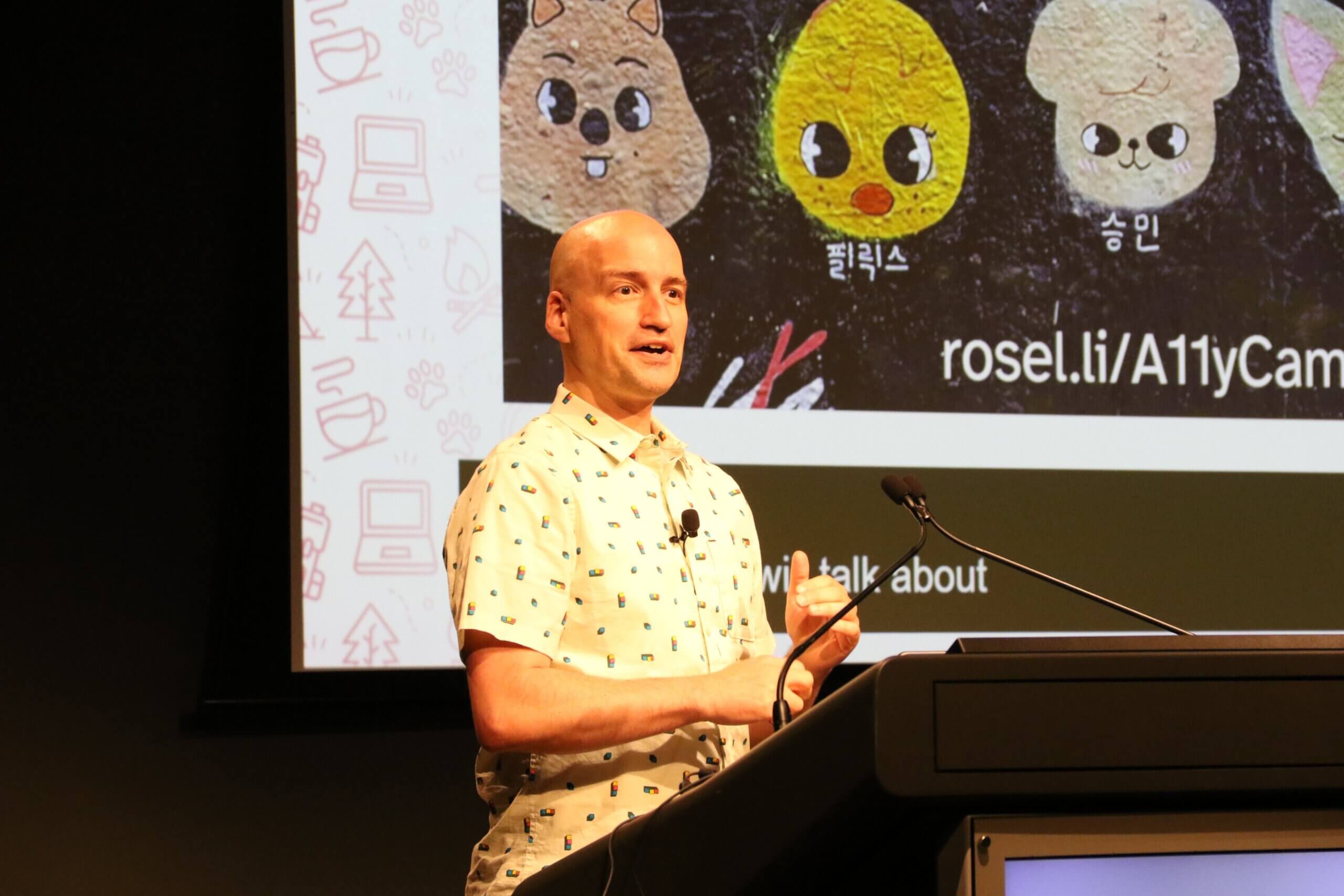 Adrian speaking in front of a lectern.