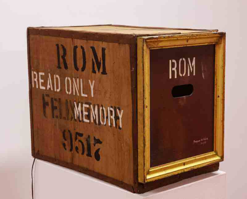 A rough-hewn wooden box with the words “Read only memory, ROM, 9517” stenciled on the side and “ROM” stenciled on the end above a small hole for grabbing.